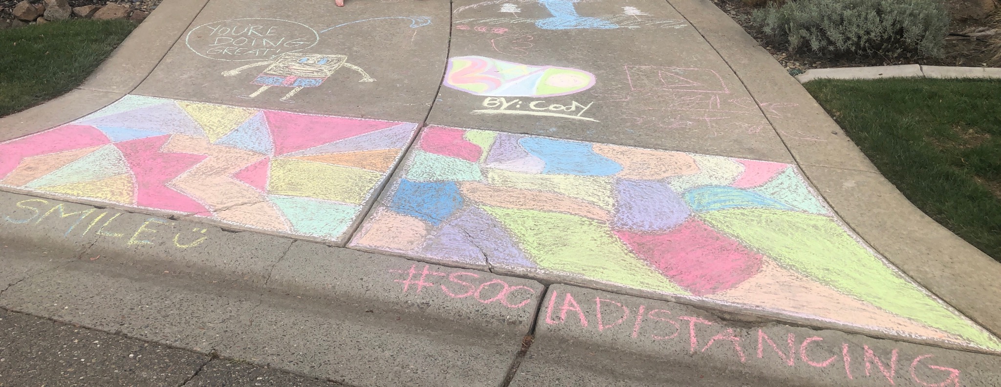 Neighborhood sidewalk features artwork from children drawn in chalk