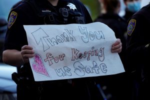 Male police officer holding a sign "Thank you for keeping us safe"
