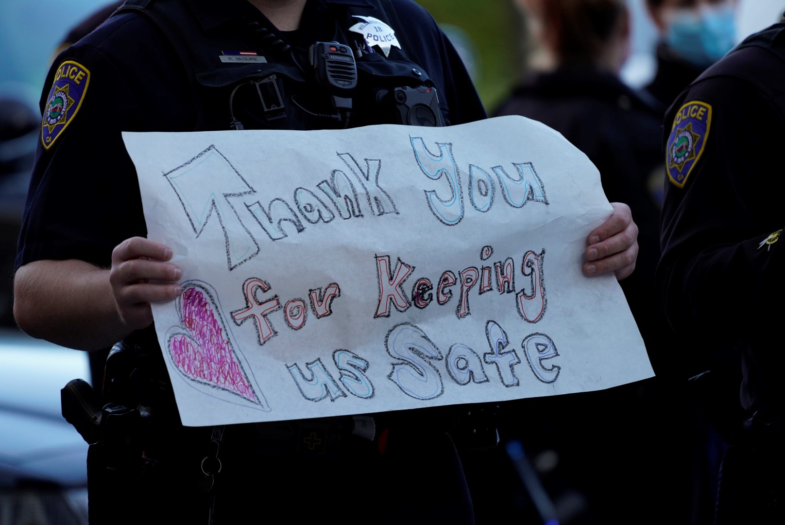 Male police officer holding a sign "Thank you for keeping us safe"