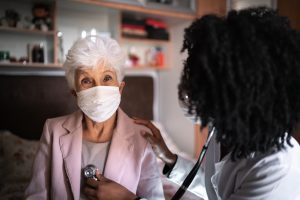 Portrait of patient - senior woman and health visitor during a home visit