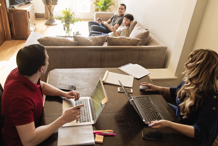 Group of young adults spend time together in living room on computers