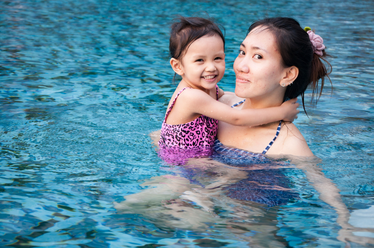 Girl playing with her mother in pool