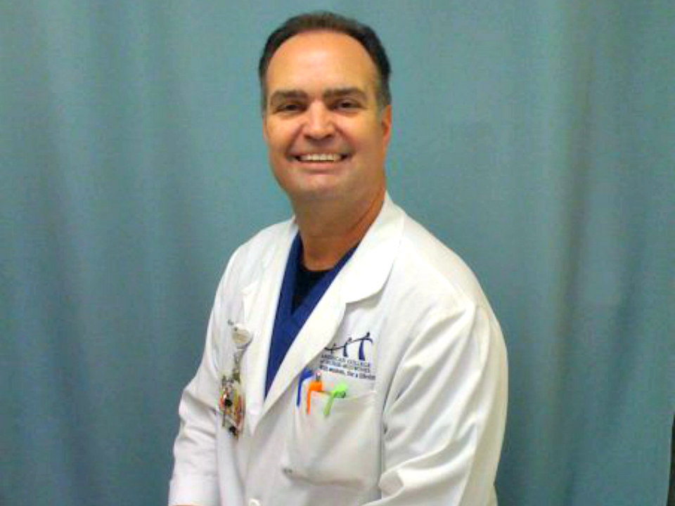 White male midwife (John Fasset) in white lab coat.