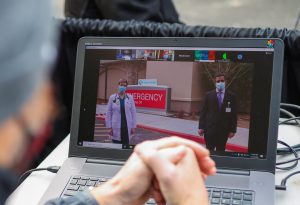 Videographer looking at computer image of two doctors