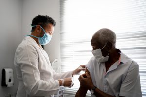 Black elderly man receiving vaccination