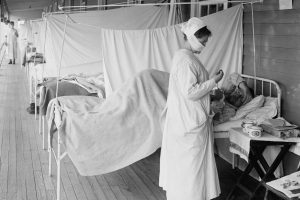 A nurse takes a patient’s pulse in the influenza ward at Walter Reed Hospital in Washington, D.C., on Nov. 1, 1918. Photo courtesy of Library of Congress.