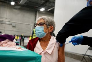 Female senior citizen wearing surgical mask received vaccine shot