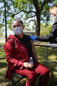 A Latina woman sits down to receive her COVID-19 vaccine at a community pop up clinic in Santa Rosa, Calif.