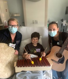 CPMC's music therapists post with Dylan Leeder, a cancer patient receiving treatment and who was helped by music therapy