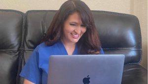 Liz Roman, physician assistant, writes from her laptop at home after work.