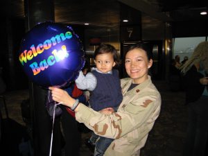 Dr. Dalal posing with sign and young child