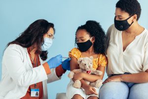 Doctor giving corona virus vaccine to a girl