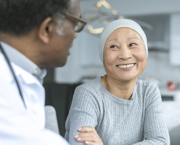 Beautiful Korean woman with cancer smiles at doctor