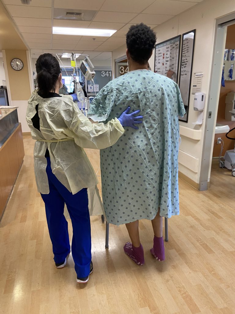 Heart transplant patient goes for hospital walk with nurse.