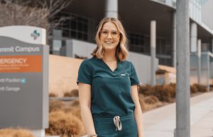 Nurse wearing scrubs in front of Alta Bates Summit Medical Center sign