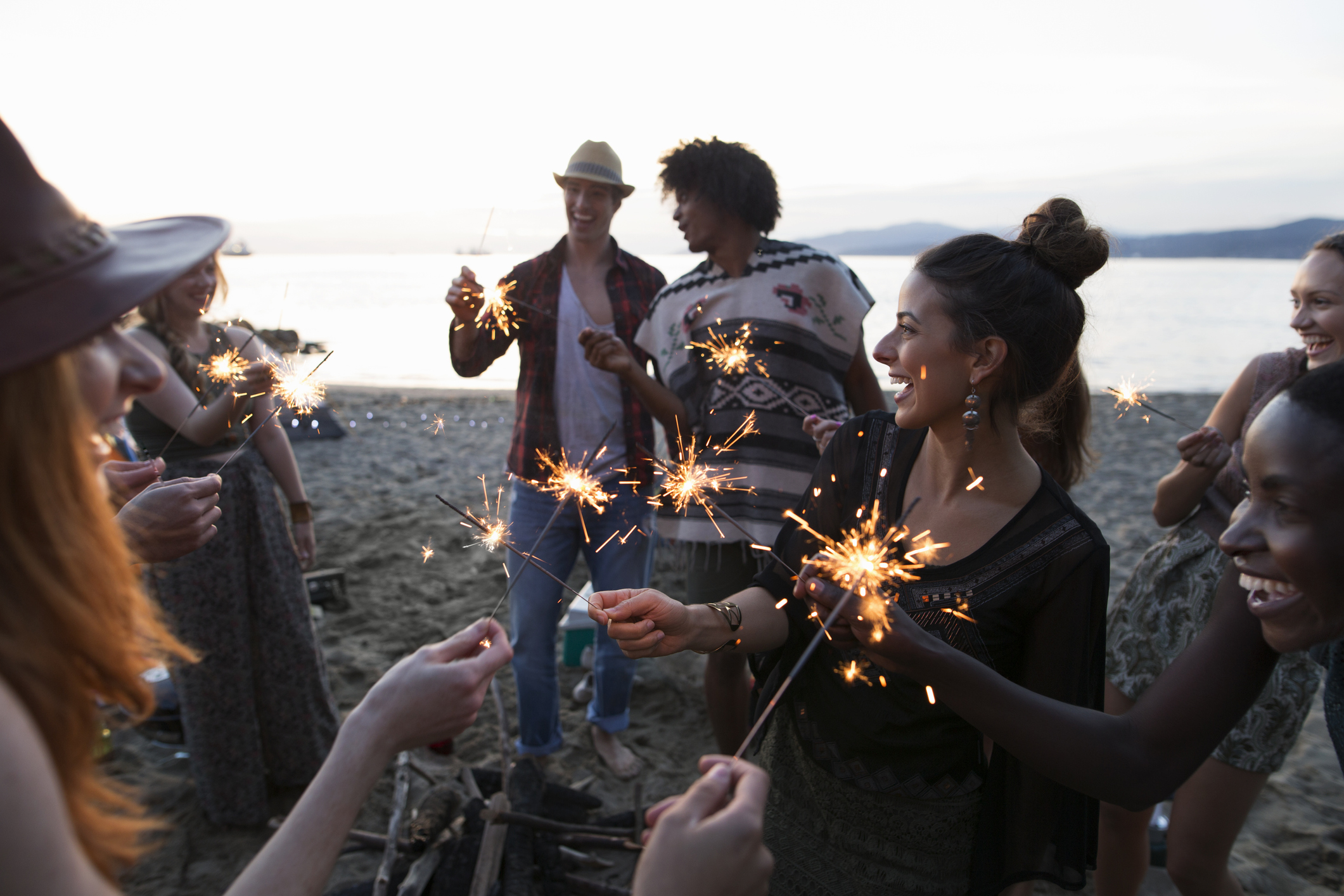 Friends playing with sparklers at beach