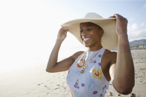 Black woman in hat enjoying the beach - stock photo