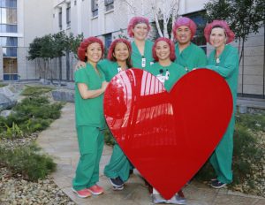 Nursing staff pose with big red heart sculpture