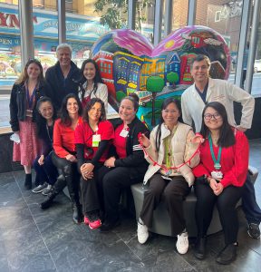 Healthcare staff pose in front of heart sculpture