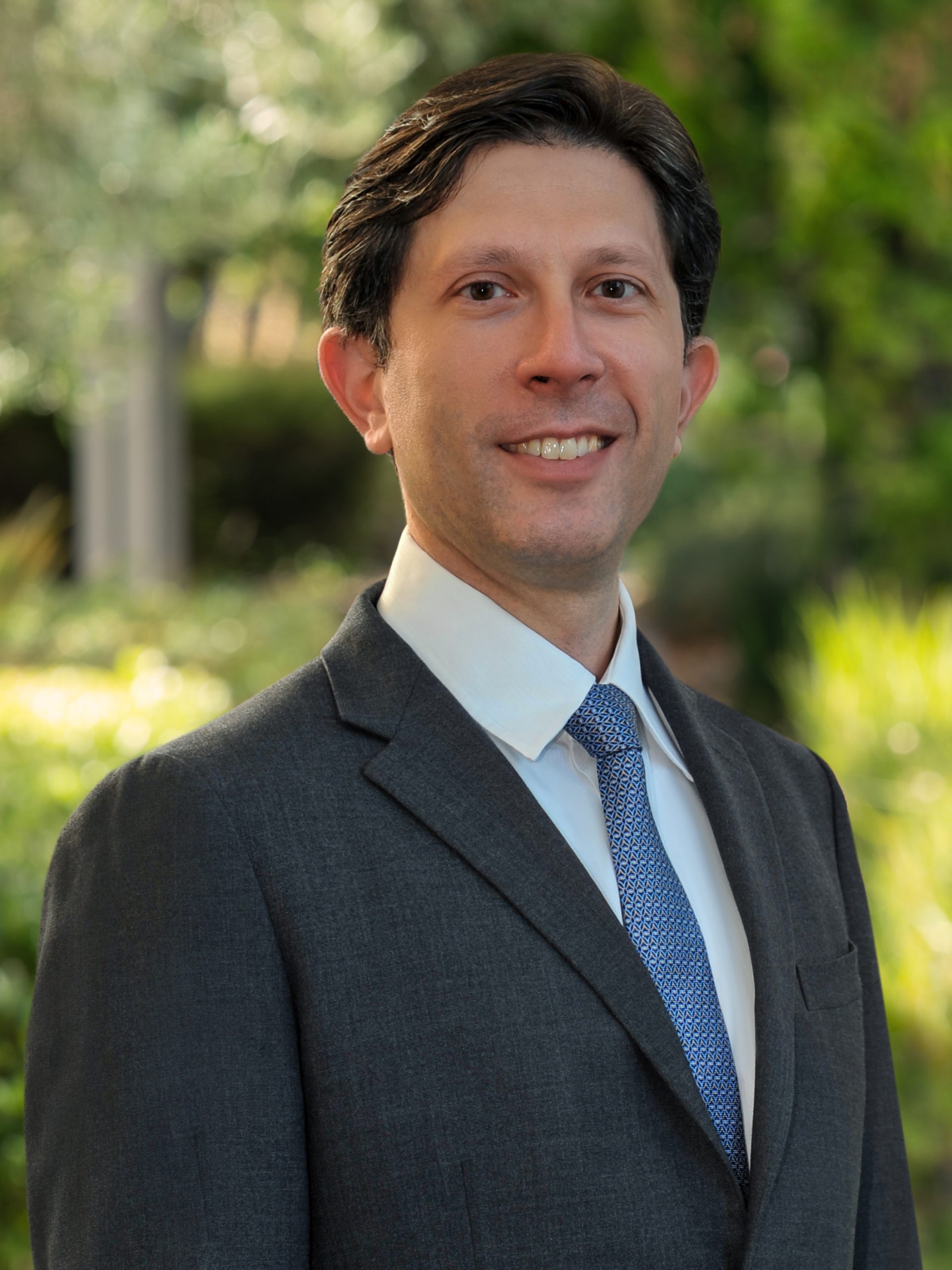 Profile shot of Dr. Fabio Settecase, a Caucasian male wearing a suit and tie outdoors