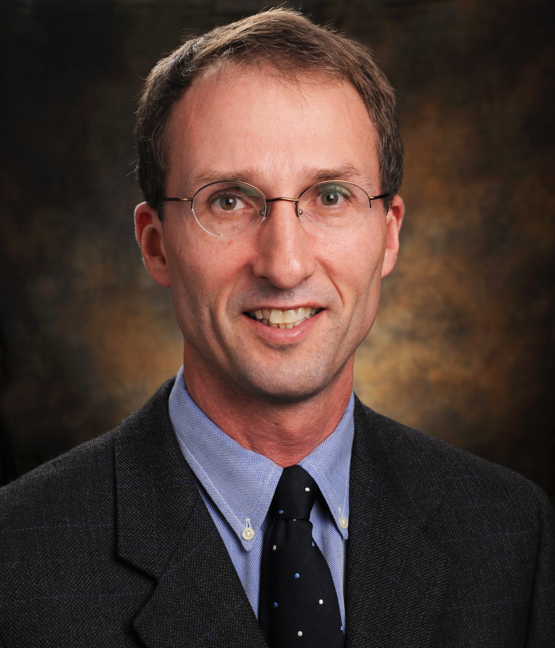 Professional photo of Dr. Joey English, a Caucasian male wearing a dark suit and tie.