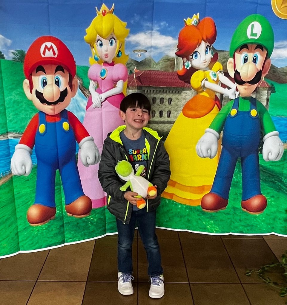 Boy in front of Mario Brothers backdrop