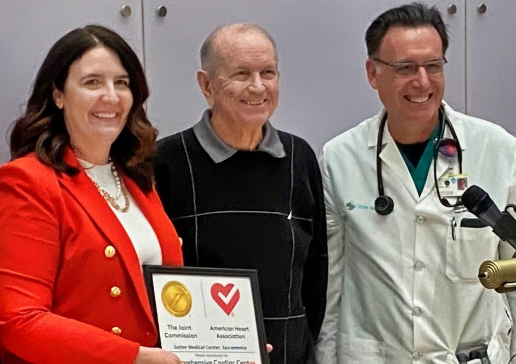 CEO, patient and doc with heart certificate.