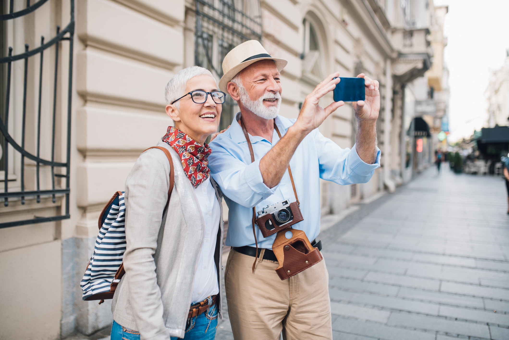 Senior couple of tourists taking photographs with phone