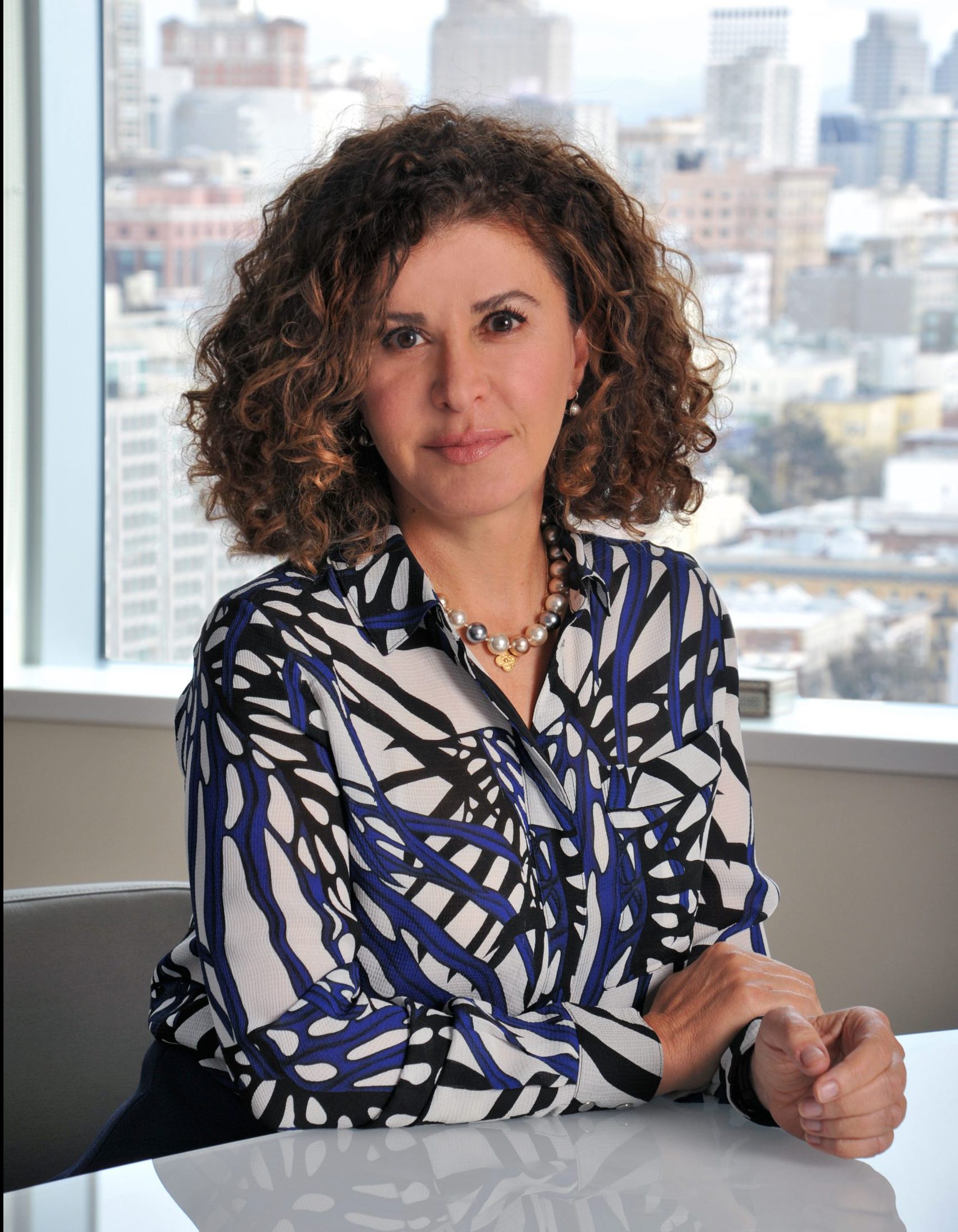 A woman with a curly hair sits at a desk