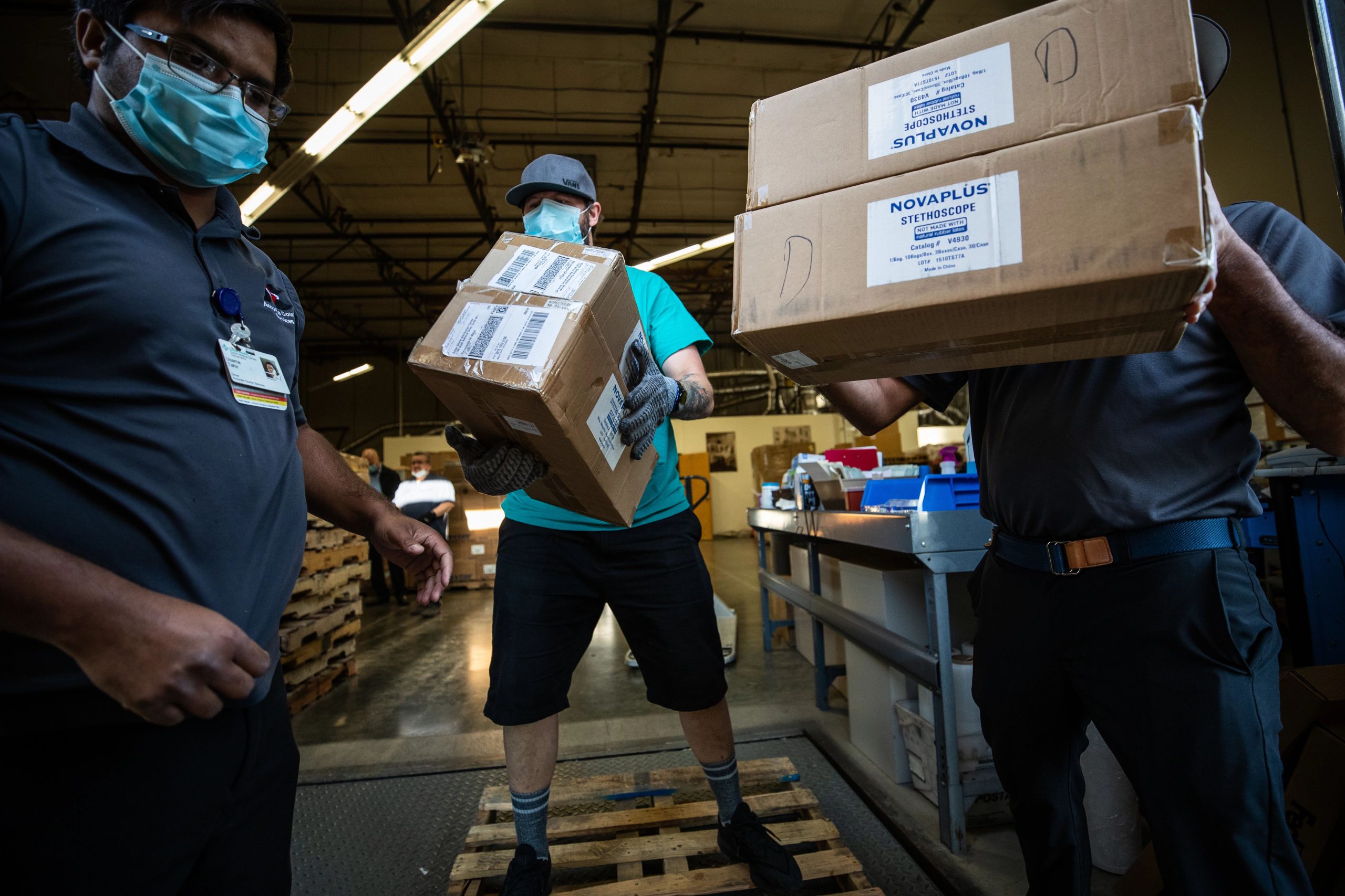 Employees from Sutter Health's supply chain warehouse in Sacramento move supplies in April 2020 during the beginning of the COVID-19 pandemic.