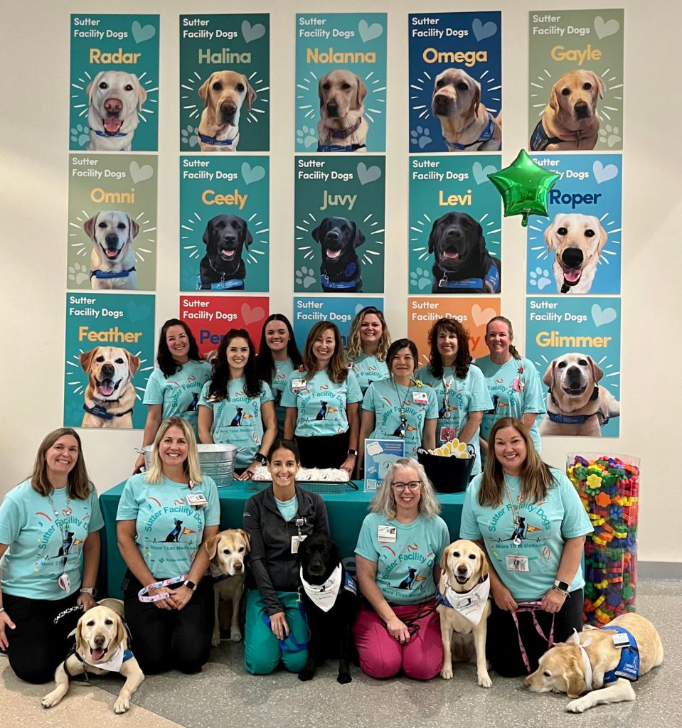 Child Life team with their dogs and the dog poster