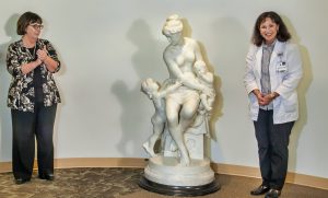 Women pose with statue during unveiling