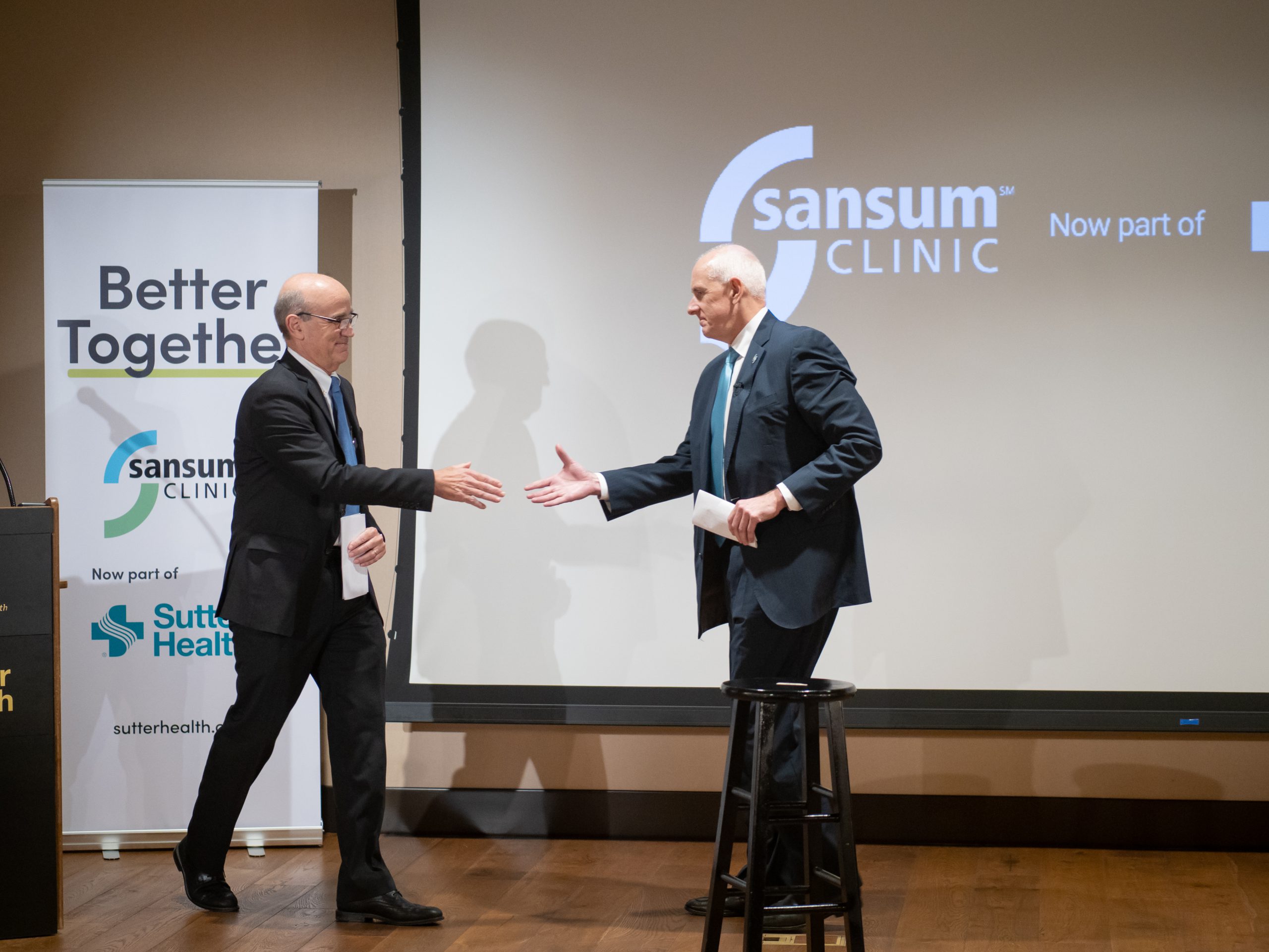 1. Kurt N. Ransohoff, MD, FACP, CEO and Chief Medical Officer, Sansum Clinic and Warner L. Thomas, President and CEO, Sutter Health, shake hands at the signing ceremony