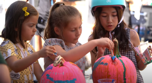 young girls painting pumpkins