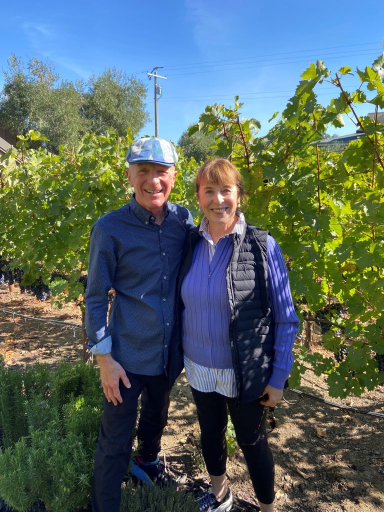 Jim and Carol White stand in a vineyard