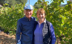Jim and Carol White stand in a vineyard