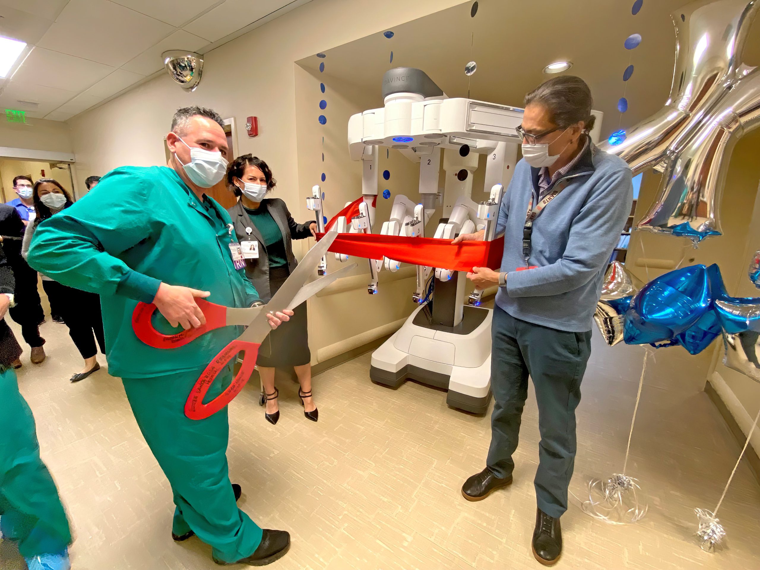 Group of medical staff cut red ribbon on new da Vinci Xi surgical robot