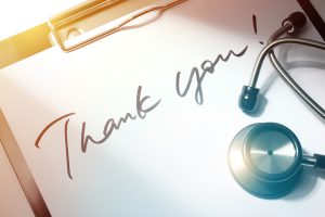 Clipboard holding paper that reads "Thank You" with a stethoscope sitting on top.