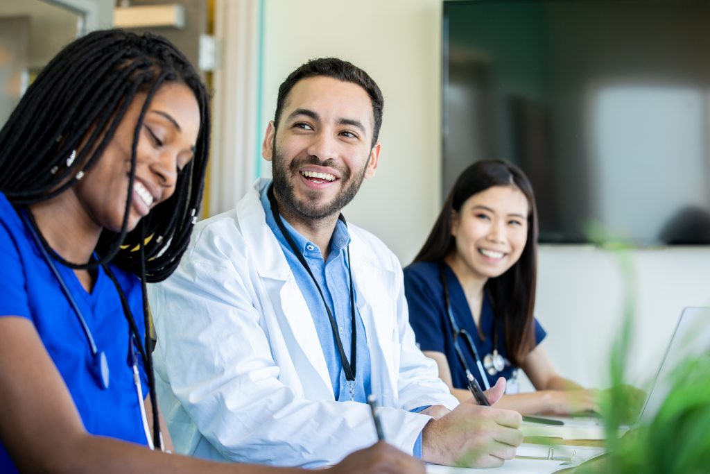 Physician residents smile during meeting in conference room