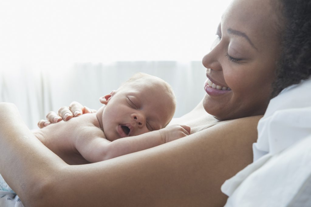 Black mother gazing lovingly at her newborn infant