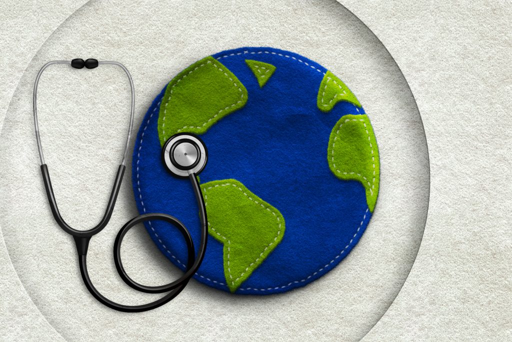 Stethoscope laying over a felt mat shaped like the Earth.