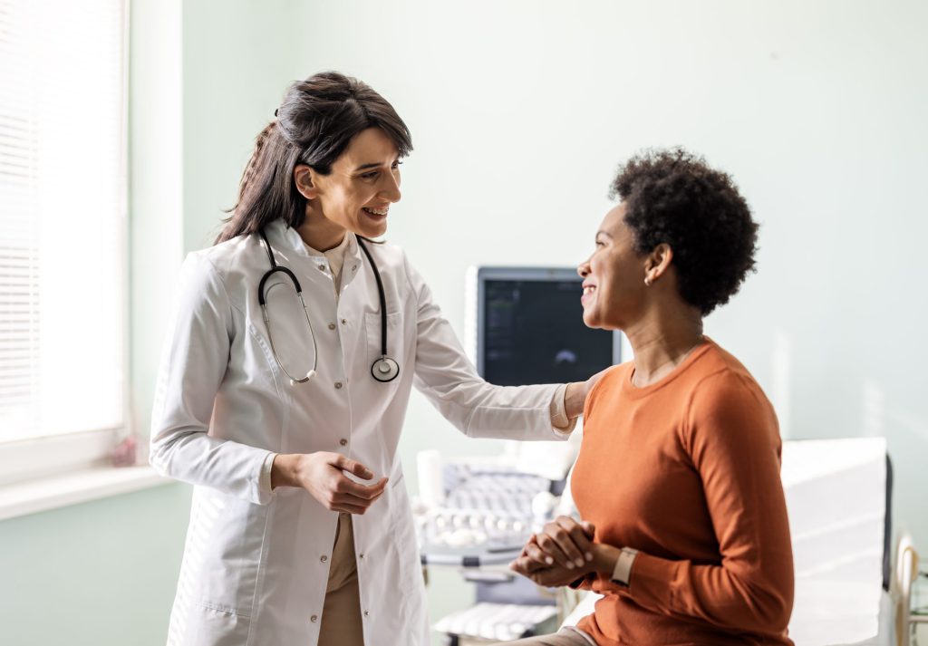 A female doctor in a white coat interacting with a patient