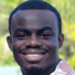 Smiling Black man in coral and white collared button-down shirt