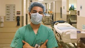 Latino man in personal protective equipment in a hospital hallway