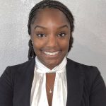 Black woman with braided hair, black blazer and white blouse