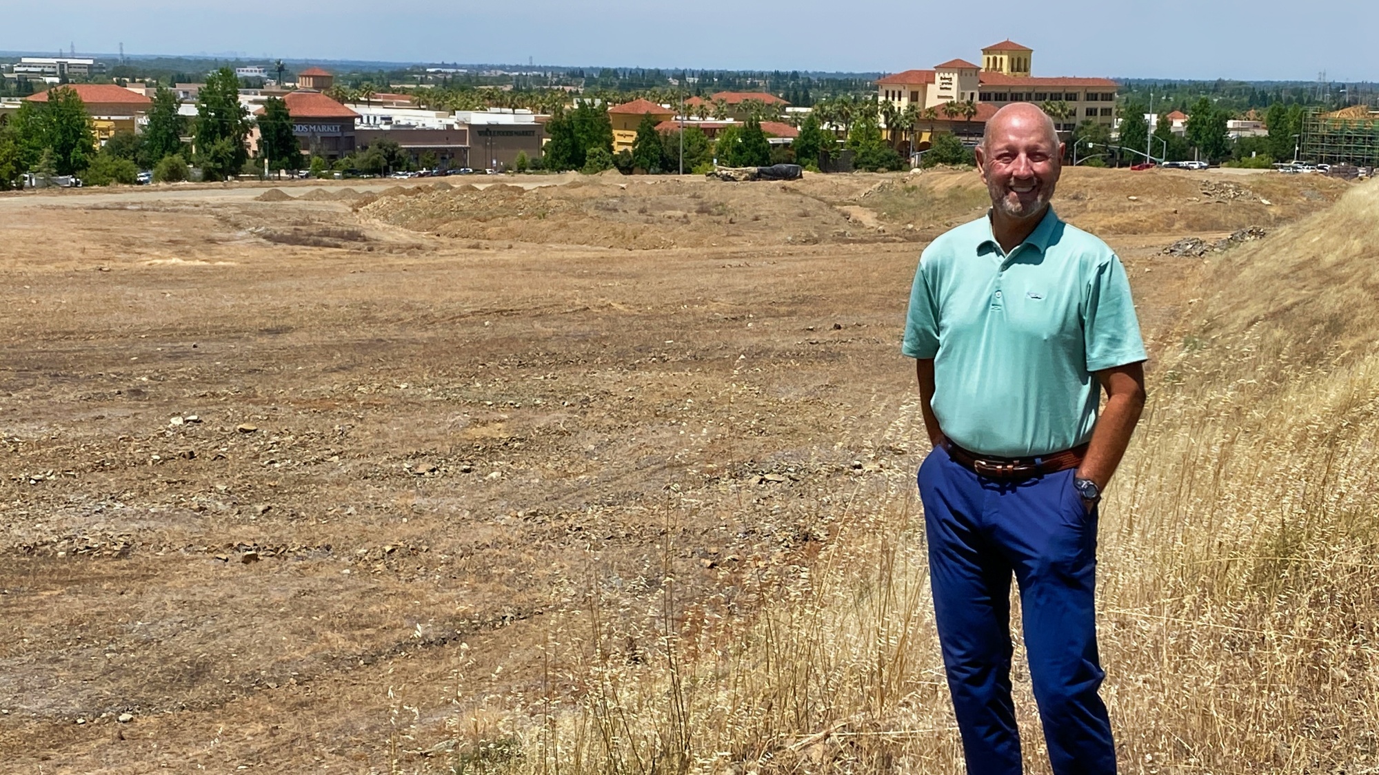 Man with field behind him.