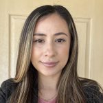 Latina woman with blondish brown long hair, black blazer and dusty rose blouse