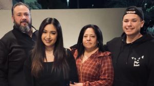 Latino family poses together for photo in backyard patio