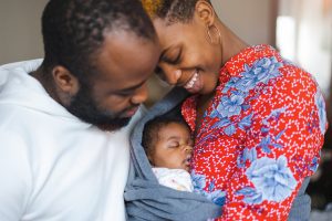 Black mom and dad admiring their newborn baby