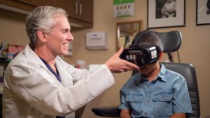 Dr. Silverberg adjusts VR goggles on his patient